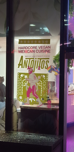 Restaurant window sign says: Hardcore Vegan Mexican Cuisine